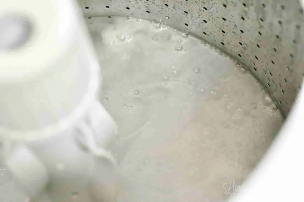 drum of washing machine filled with water, vinegar, and baking soda.