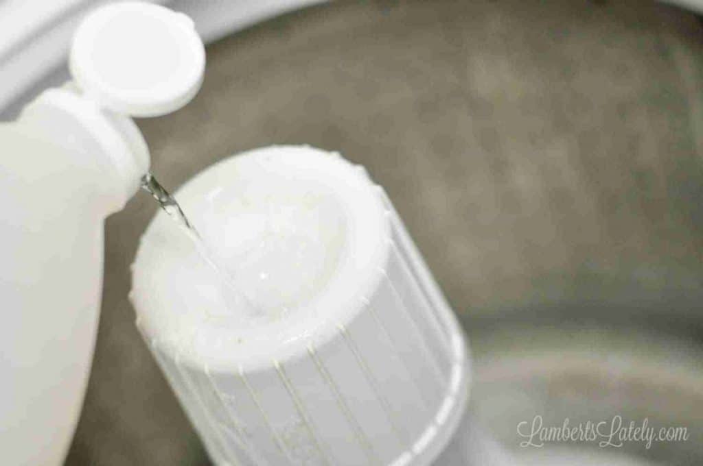pouring vinegar into the fabric softener dispenser on a speed queen.