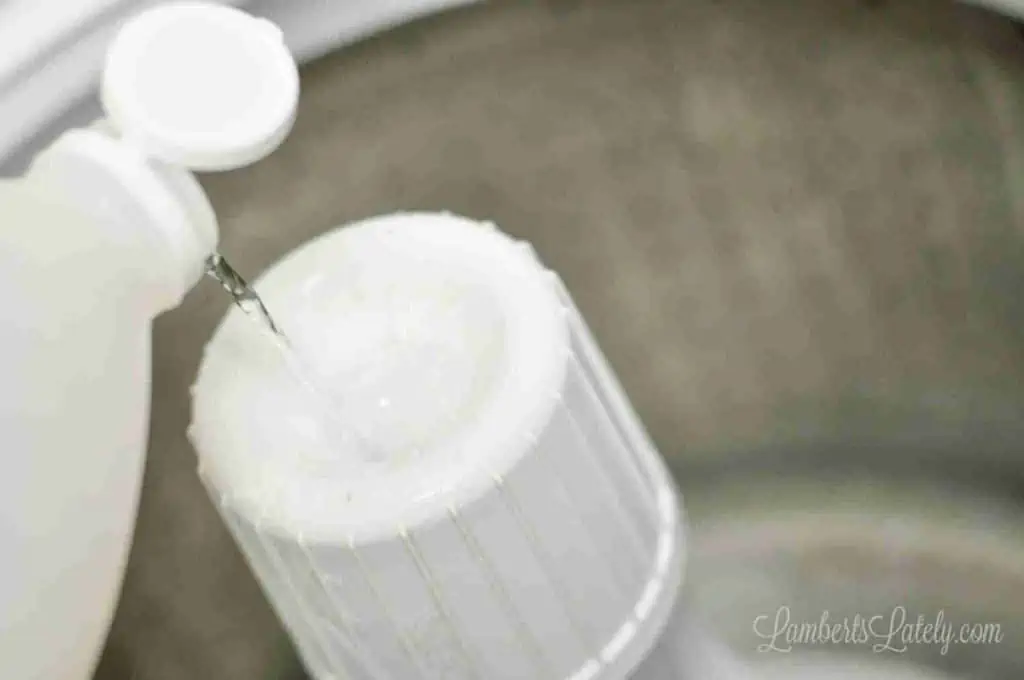 pouring vinegar into the fabric softener dispenser on a speed queen.