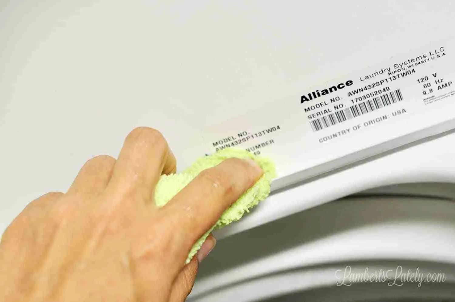 cleaning edge of washing machine door with a microfiber cloth