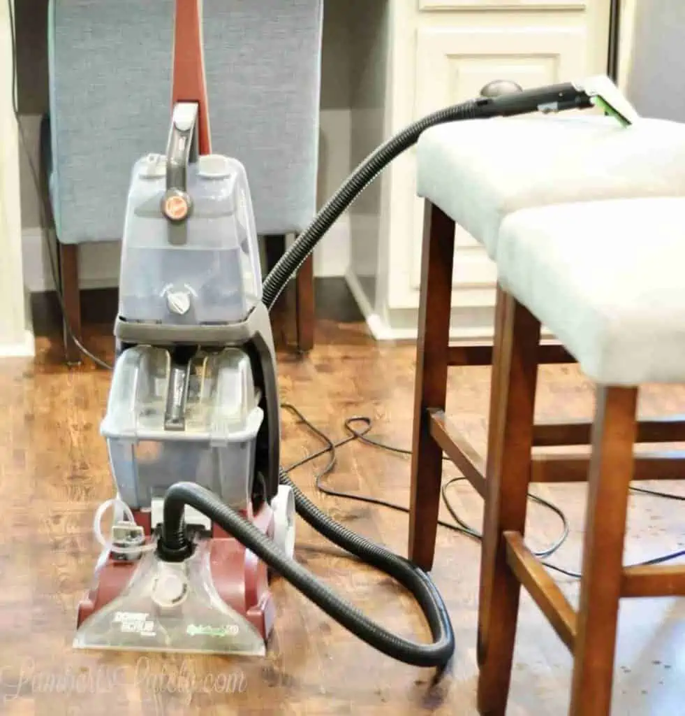 Hoover carpet cleaner sitting next to upholstered chairs.
