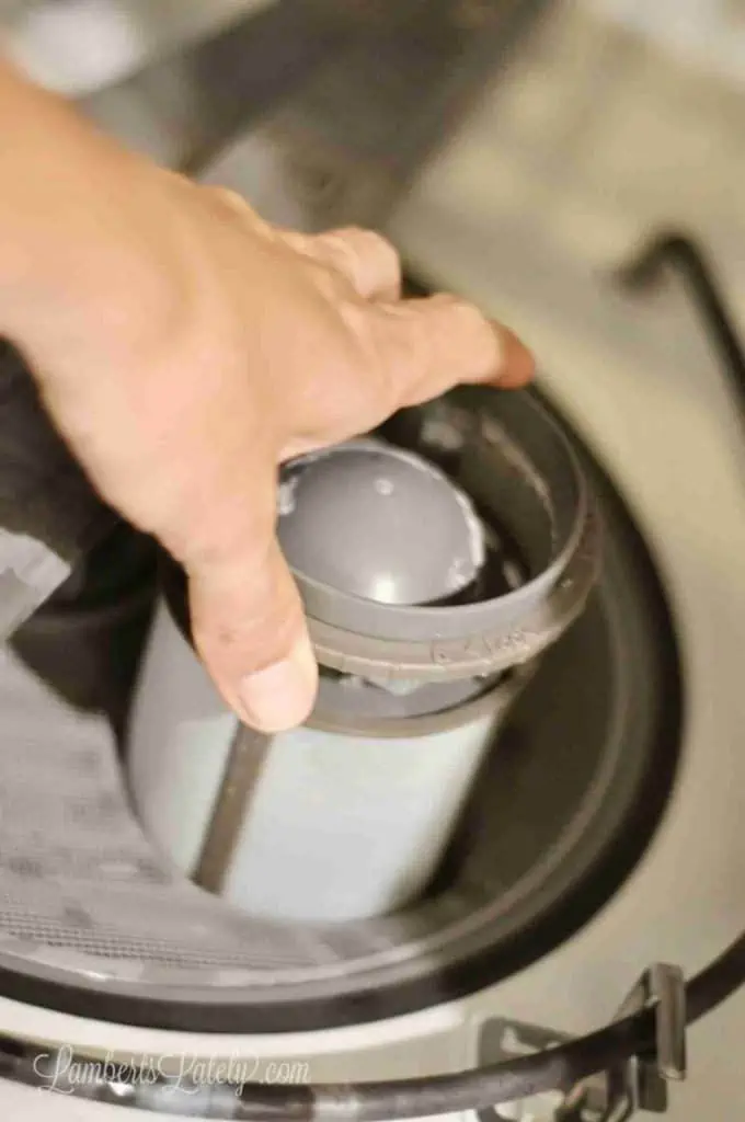 unscrewing a dishwasher filter
