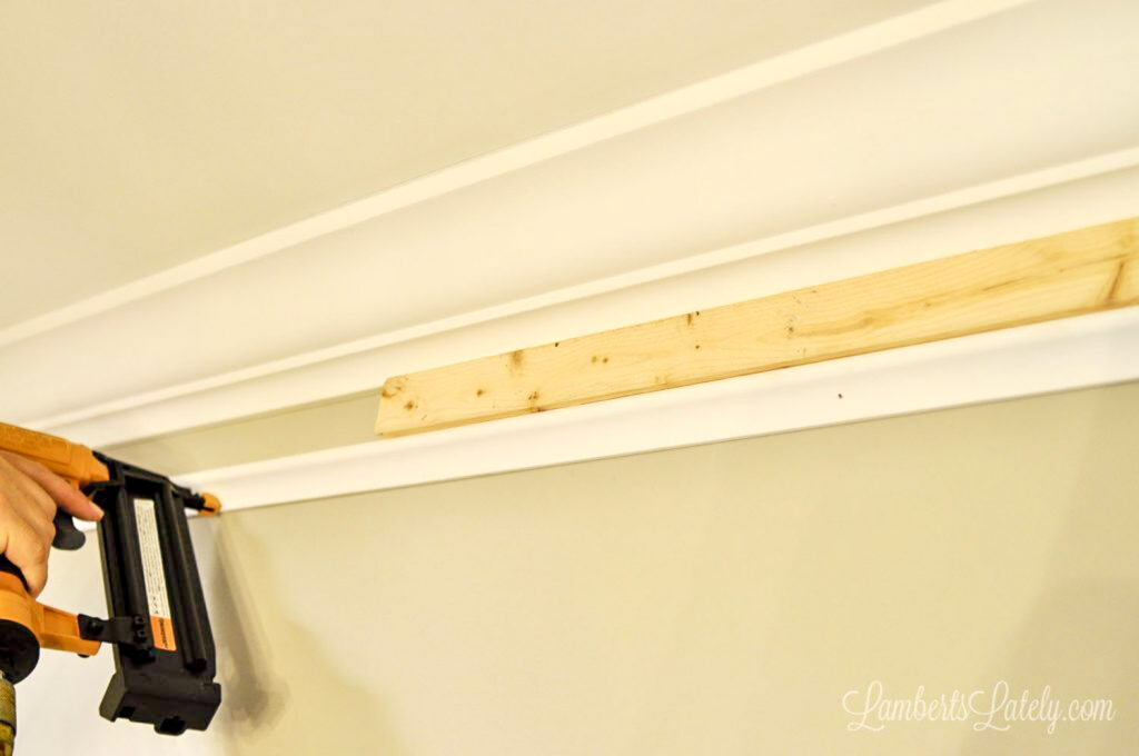 Using a 1x2 wood spacer to install DIY faux crown molding.