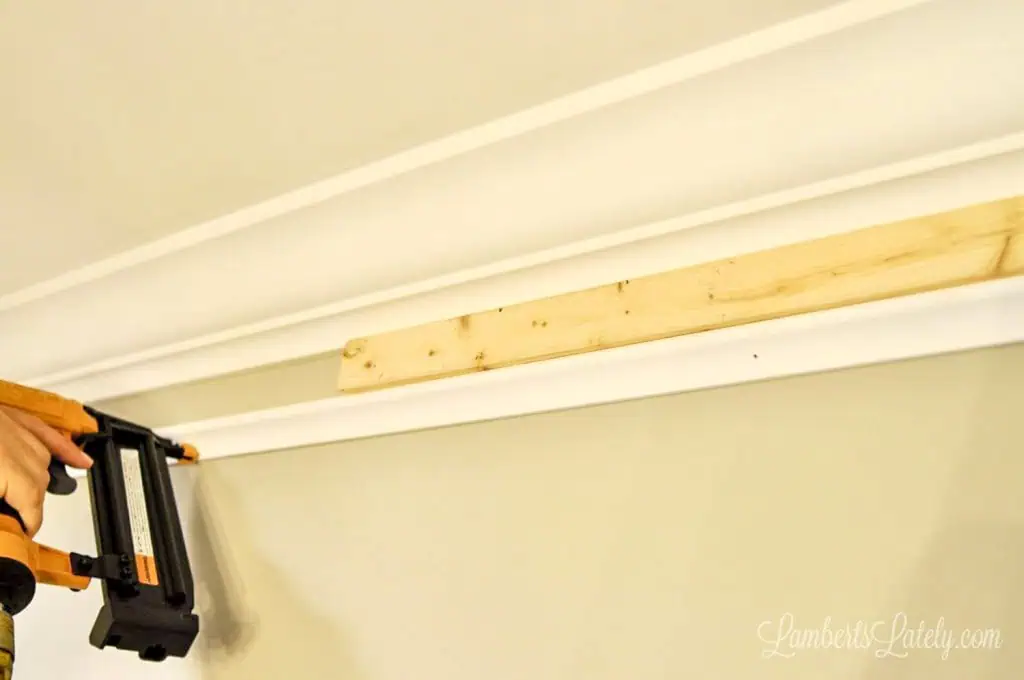 Using a 1x2 wood spacer to install DIY faux crown molding.