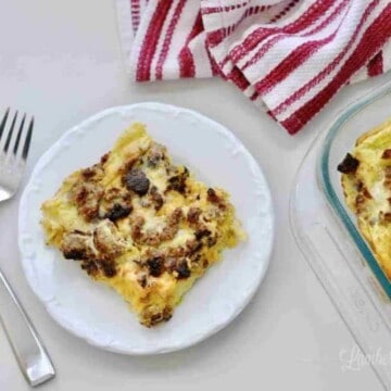 breakfast casserole serving on a plate, with baking dish and two forks.