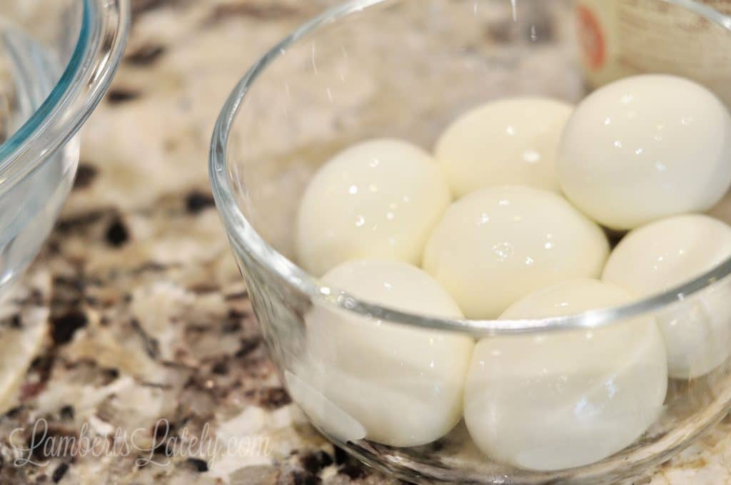 peeled hard boiled eggs in a glass bowl.