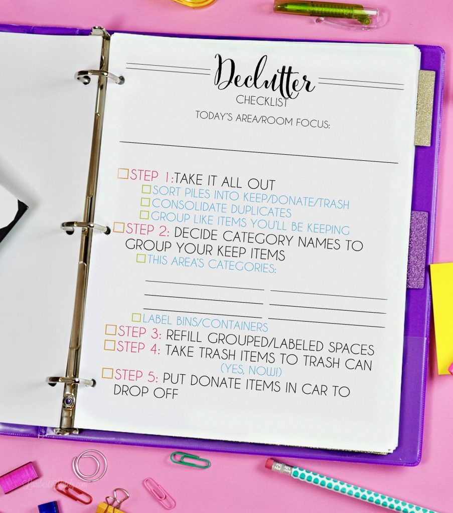 Free printable decluttering checklist in a notebook on a pink desk