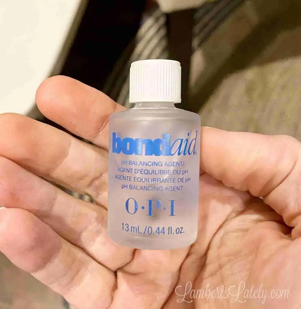 holding a bottle of OPI bond aid.