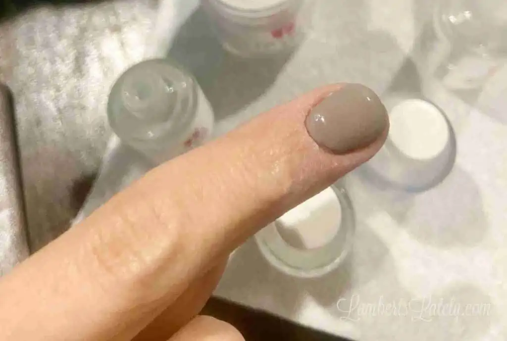 revel nail shady dip powder on a finger.