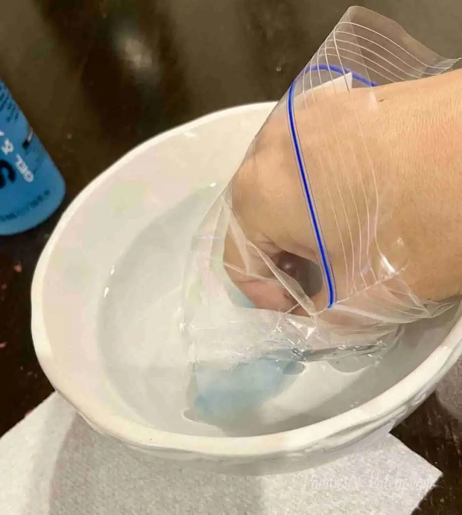 hand in a plastic bag, submerged in warm water