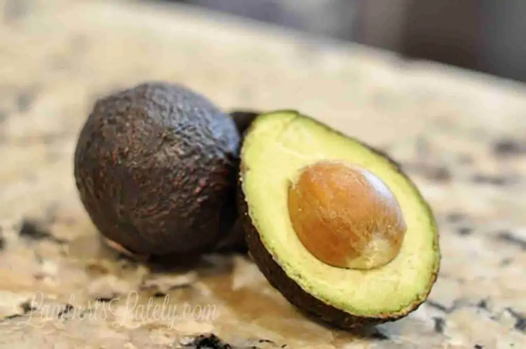 avocado cut in half on a countertop.