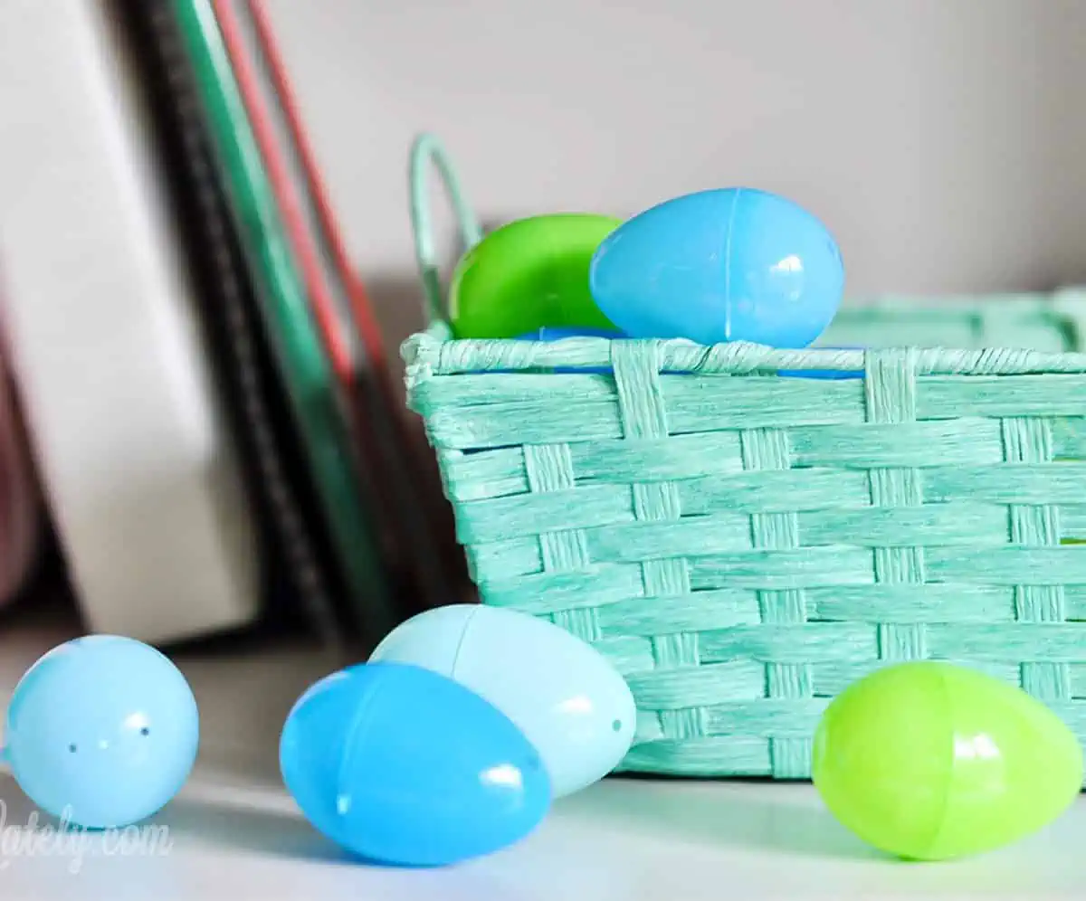 blue easter basket with plastic eggs on a shelf.