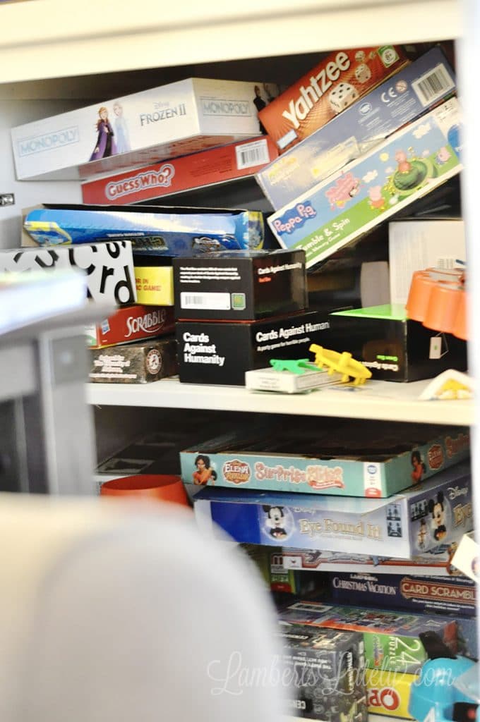unorganized board games in a small cabinet