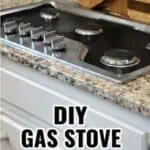 Close-up of a gas stove with a wooden splash guard on the countertop.