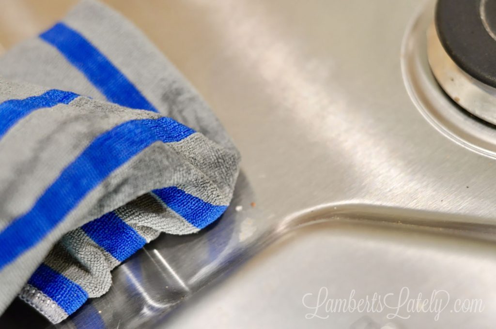 cleaning stainless steel stovetop with a cloth