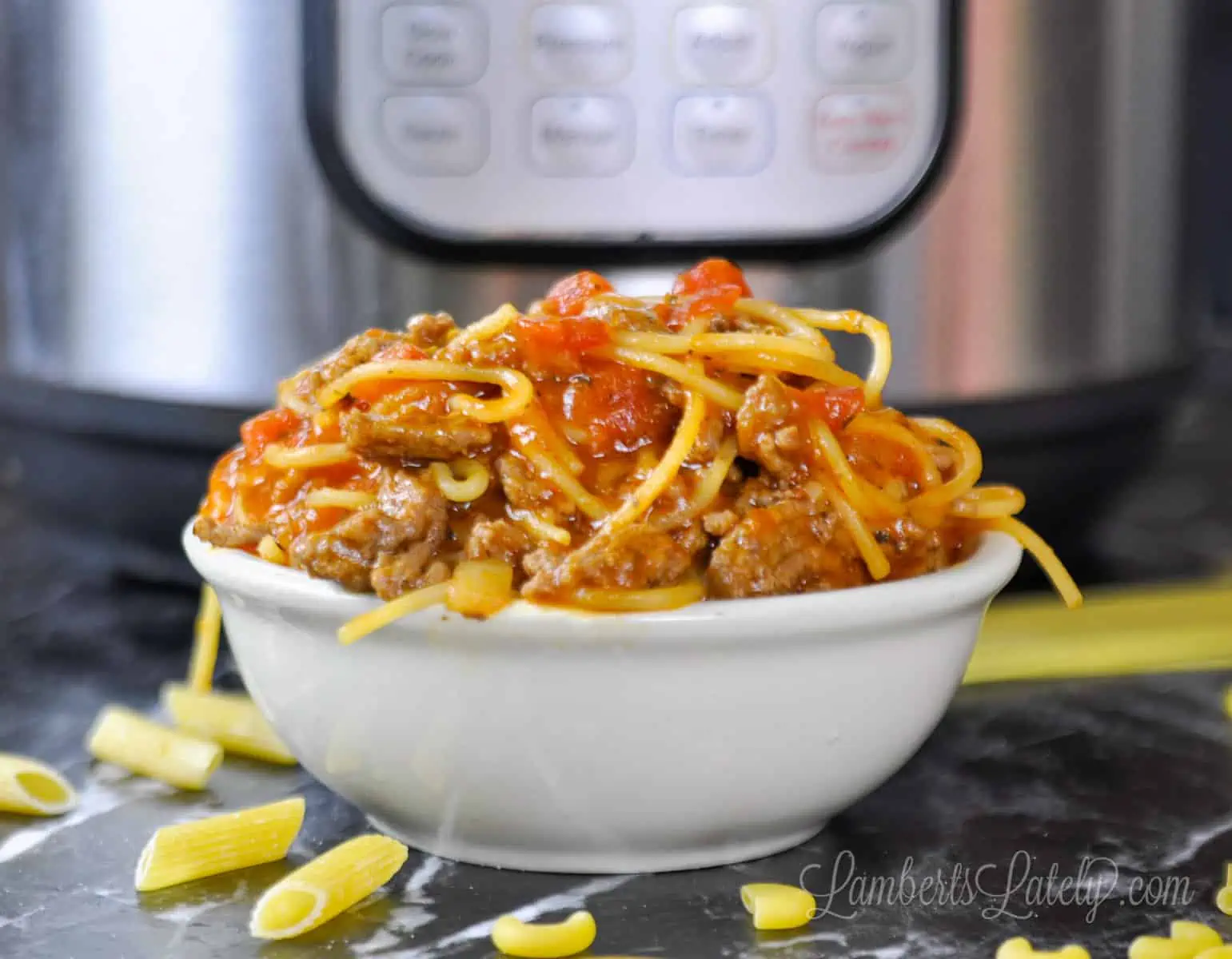 spaghetti in a bowl in front of an instant pot.