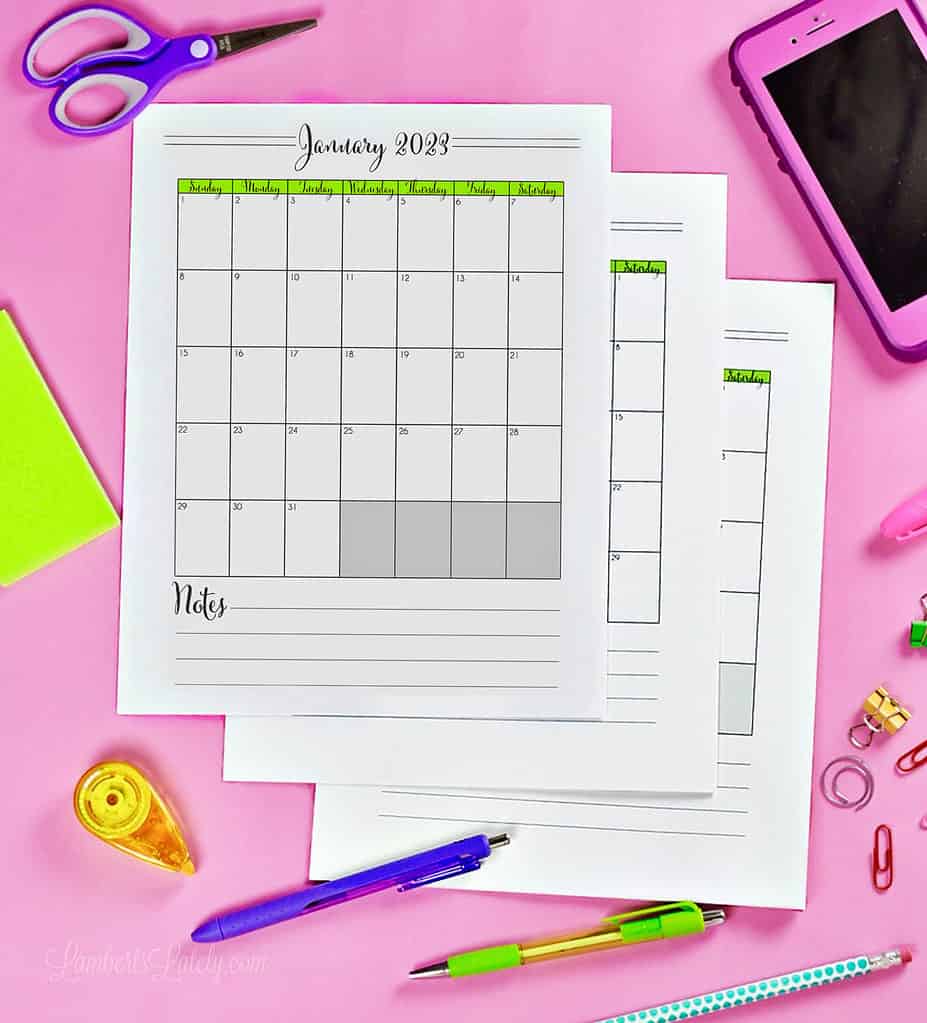 three calendar pages laying on a pink desk.