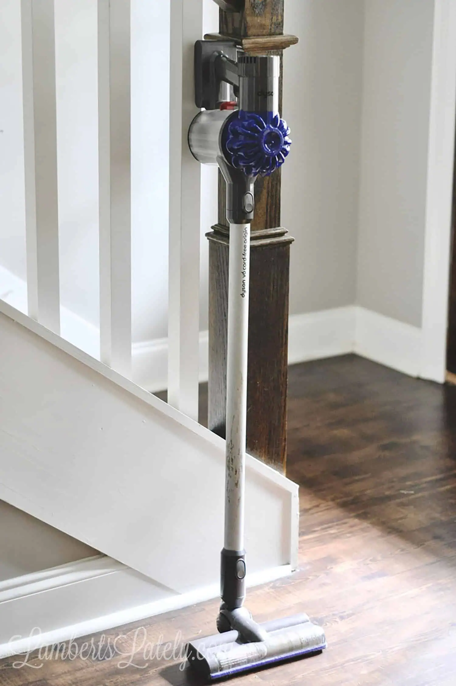 dyson animal vacuum leaning against stair railing.