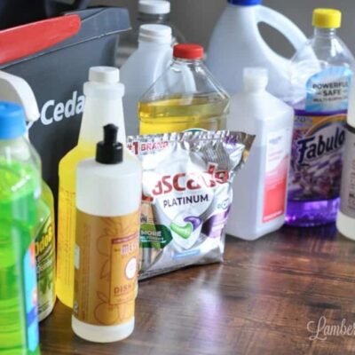 different cleaners on a floor in front of a mopping bucket.