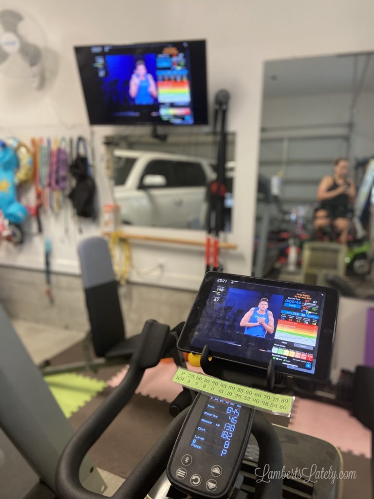 Ipad on a Schwinn IC4 in a garage gym with mirrors.