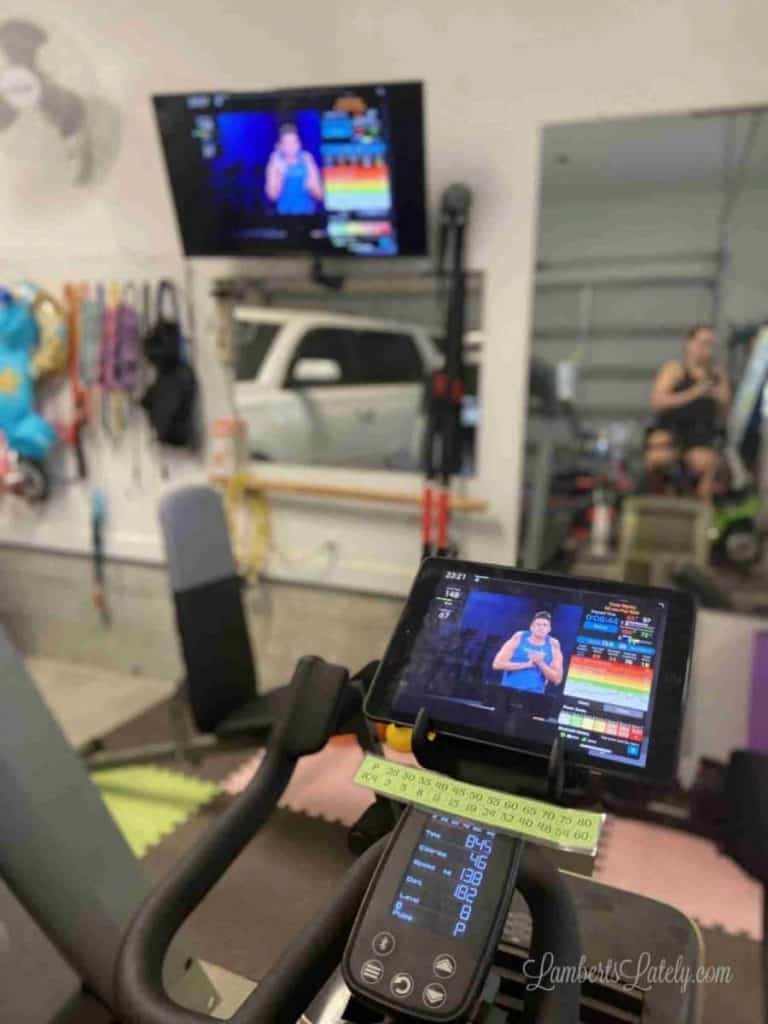Ipad on a Schwinn IC4 in a garage gym with mirrors.