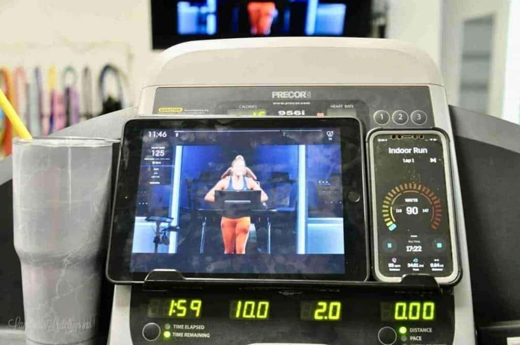 iPad playing a peloton tread workout, sitting on a treadmill
