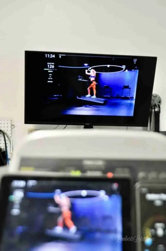 a television airplaying a peloton tread workout.
