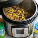 Instant Pot Mississippi Pot Roast with shredded beef and peppers in a modern pressure cooker.