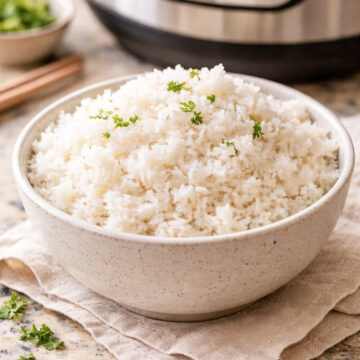 bowl of fluffy white rice in front of an instant pot pressure cooker.