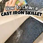 Person cleaning a cast iron griddle with a sponge in a kitchen sink.