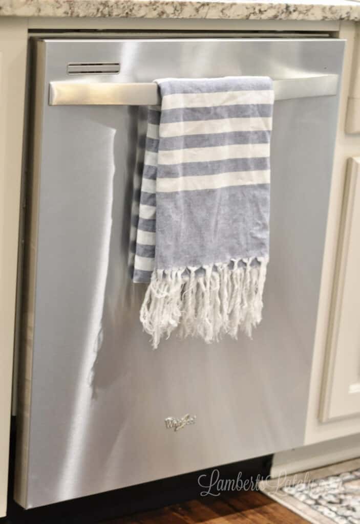 stainless steel dishwasher with a blue towel hanging on handle