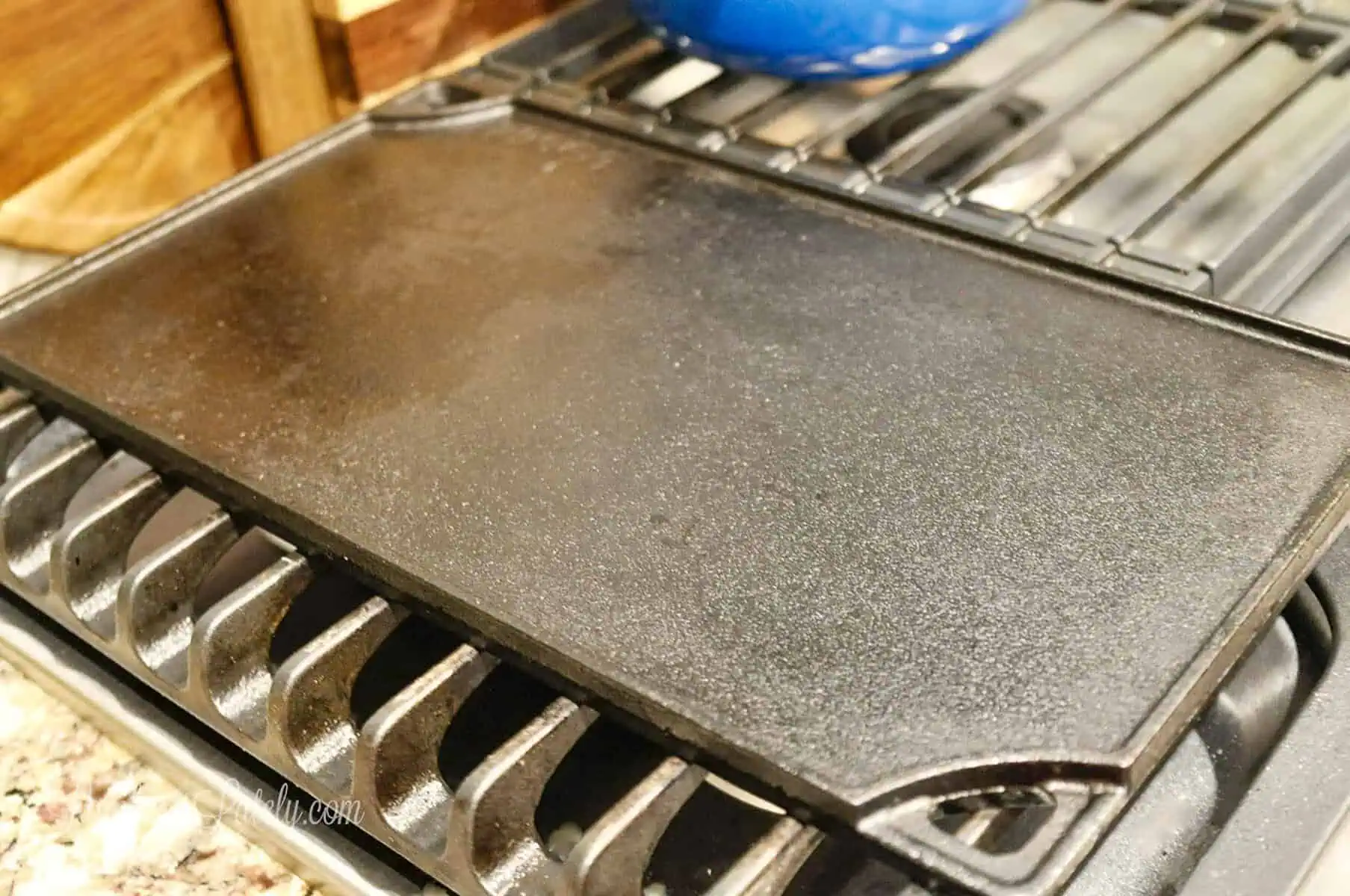 cleaned, seasoned cast iron griddle on a gas stove.