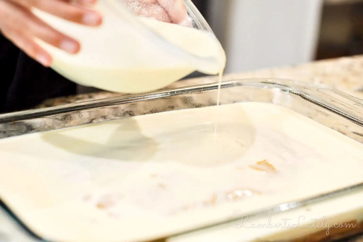pouring a tres leches mixture over the pumpkin sheet cake.