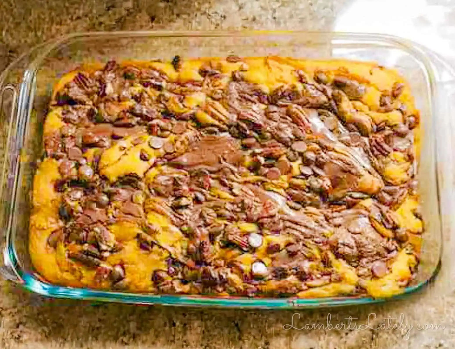 Pumpkin earthquake cake topped with pecans in a glass baking dish.