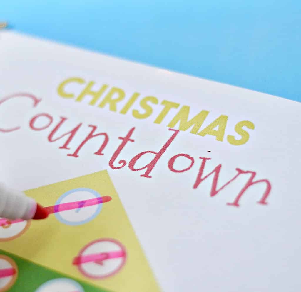 Christmas countdown printable with colorful circles and a red marker pen.