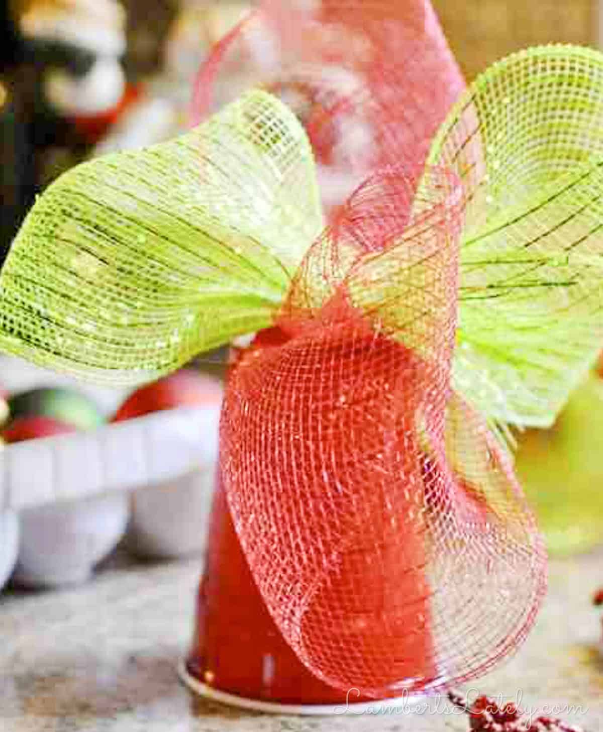 Deco mesh bow glued to plastic cup base for homemade Christmas tree topper.