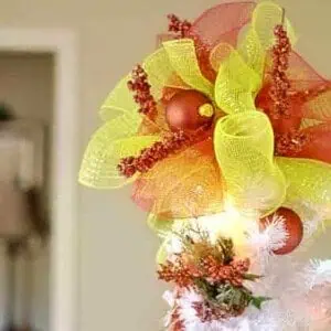 red and green tree topper on top of a white tree.