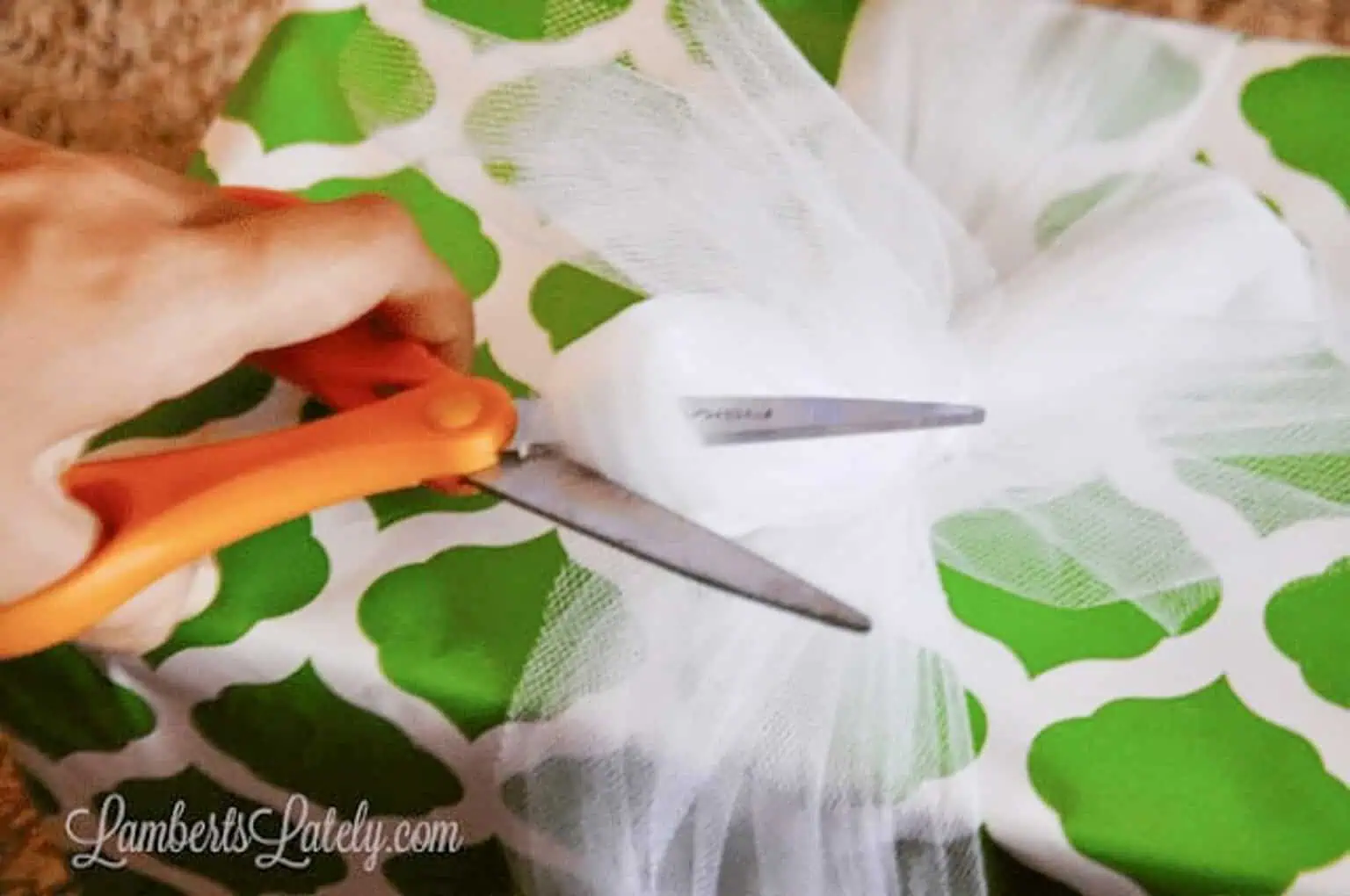 using a pair of scissors to cut the loops in the bow.