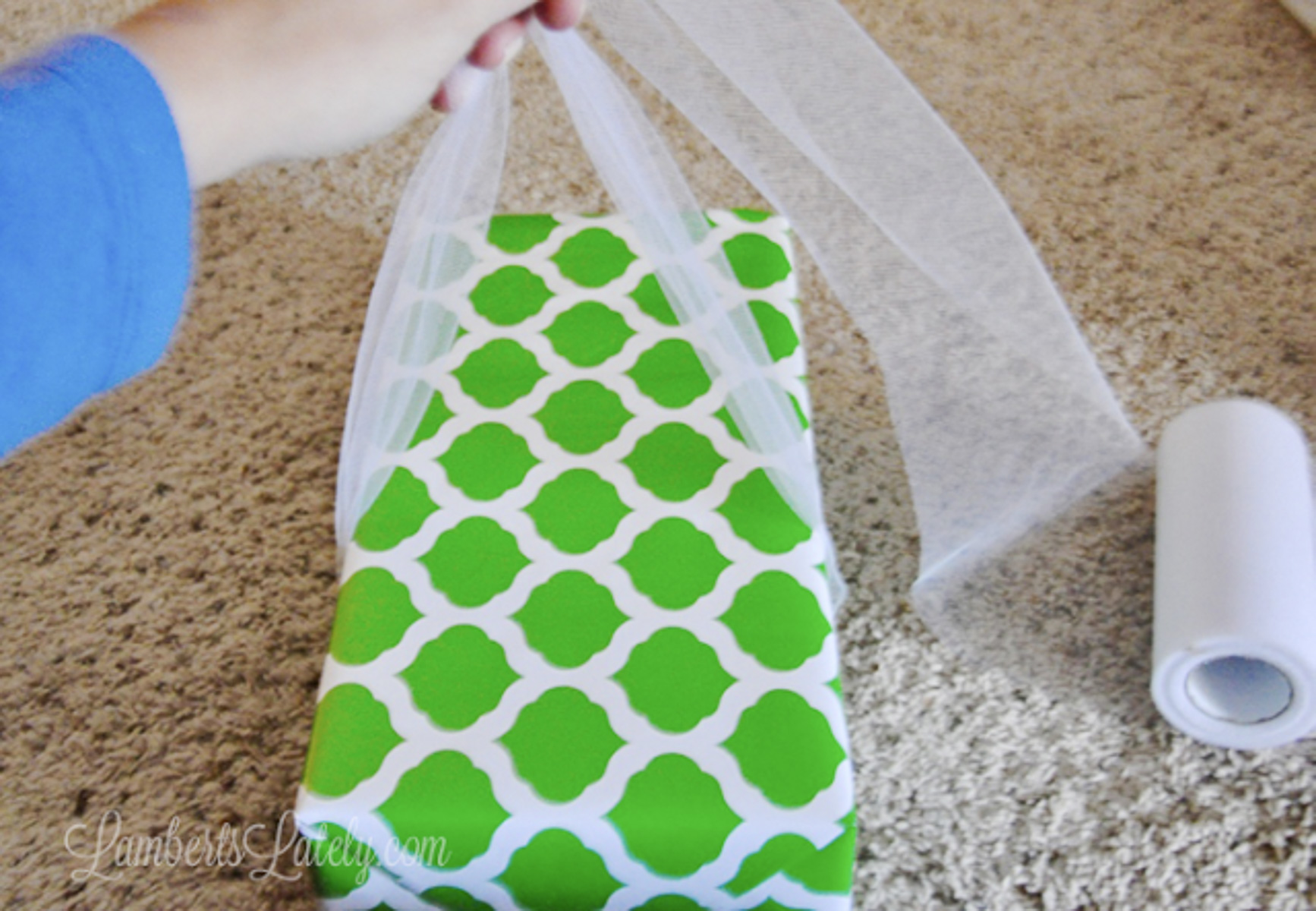 holding tulle around a wrapped gift, with about 8 inches extra on each side.