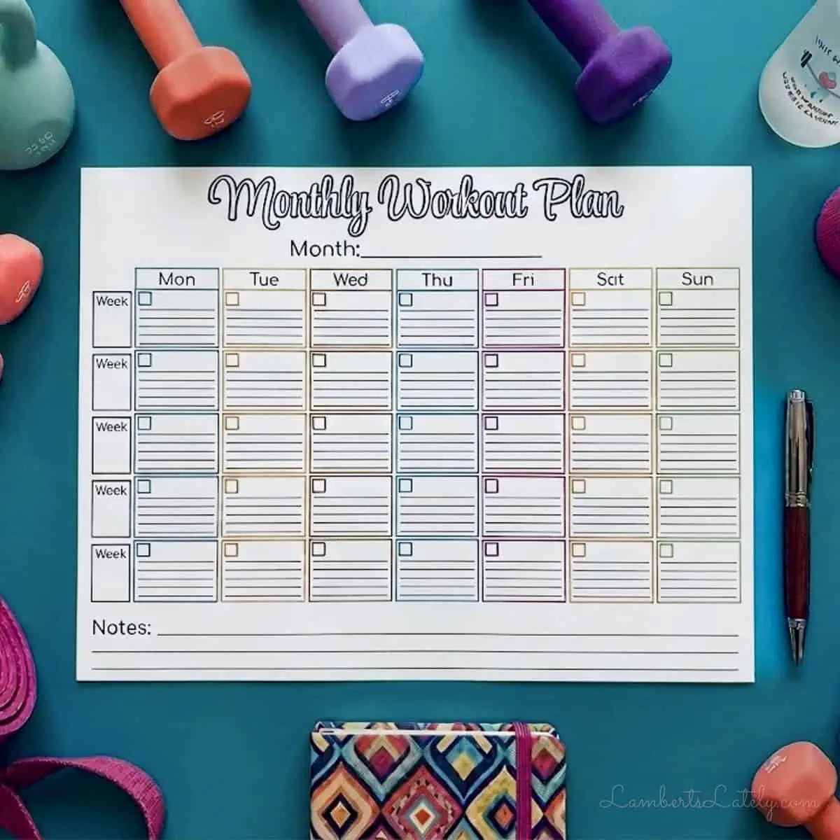 monthly workout calendar printed on 8.5x11 paper, surrounded by exercise gear.