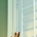 DIY indoor plantation shutter being installed on a window.