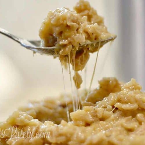 holding a fork of cheesy chicken and rice in front of an instant pot.