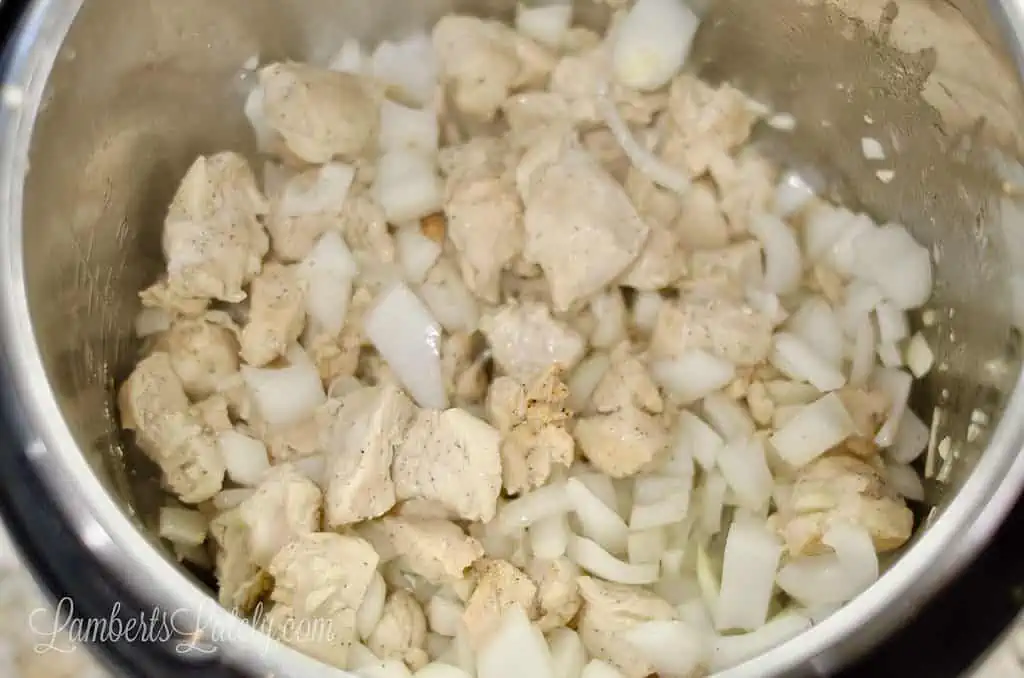 chicken, onion, and garlic cooking in an instant pot.