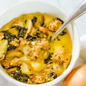 looking down on a bowl of zuppa toscana with a spoon in it.