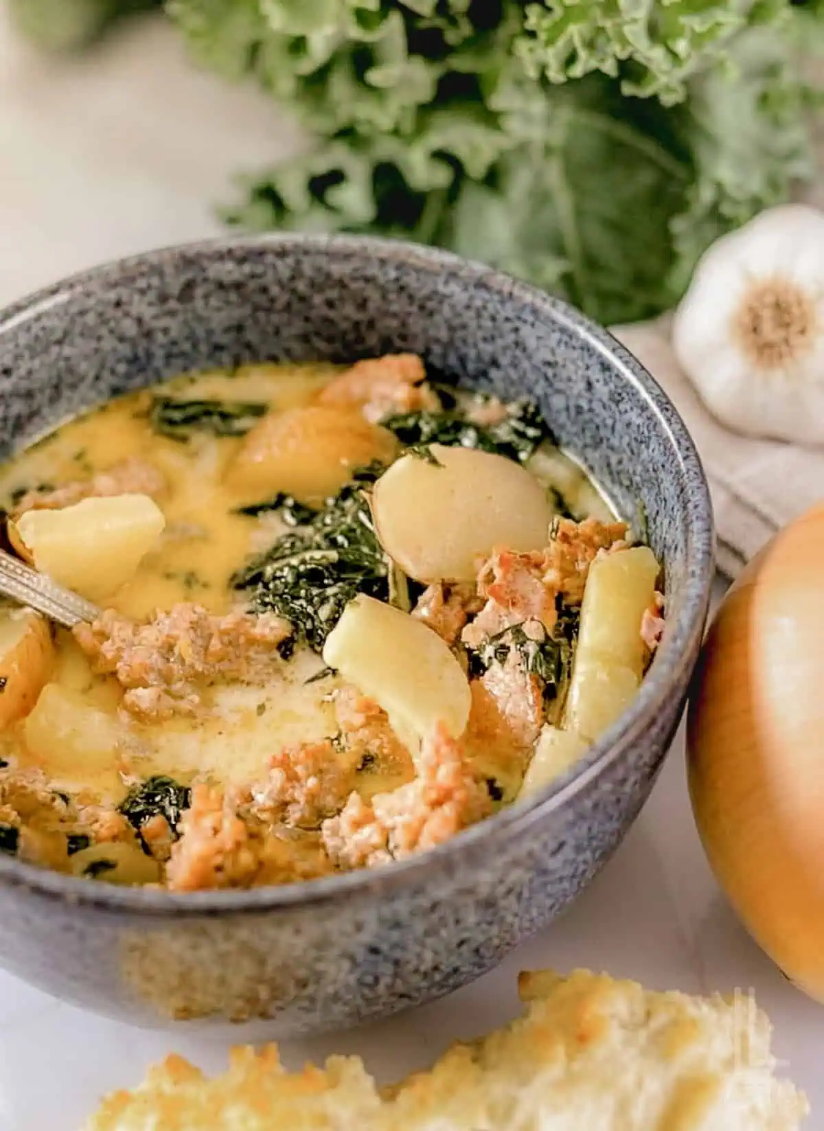 A bowl of creamy Instant Pot Zuppa Toscana with kale, sausage, and potatoes.