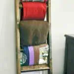 Wooden blanket ladder with colorful blankets hanging on it, DIY home decor.