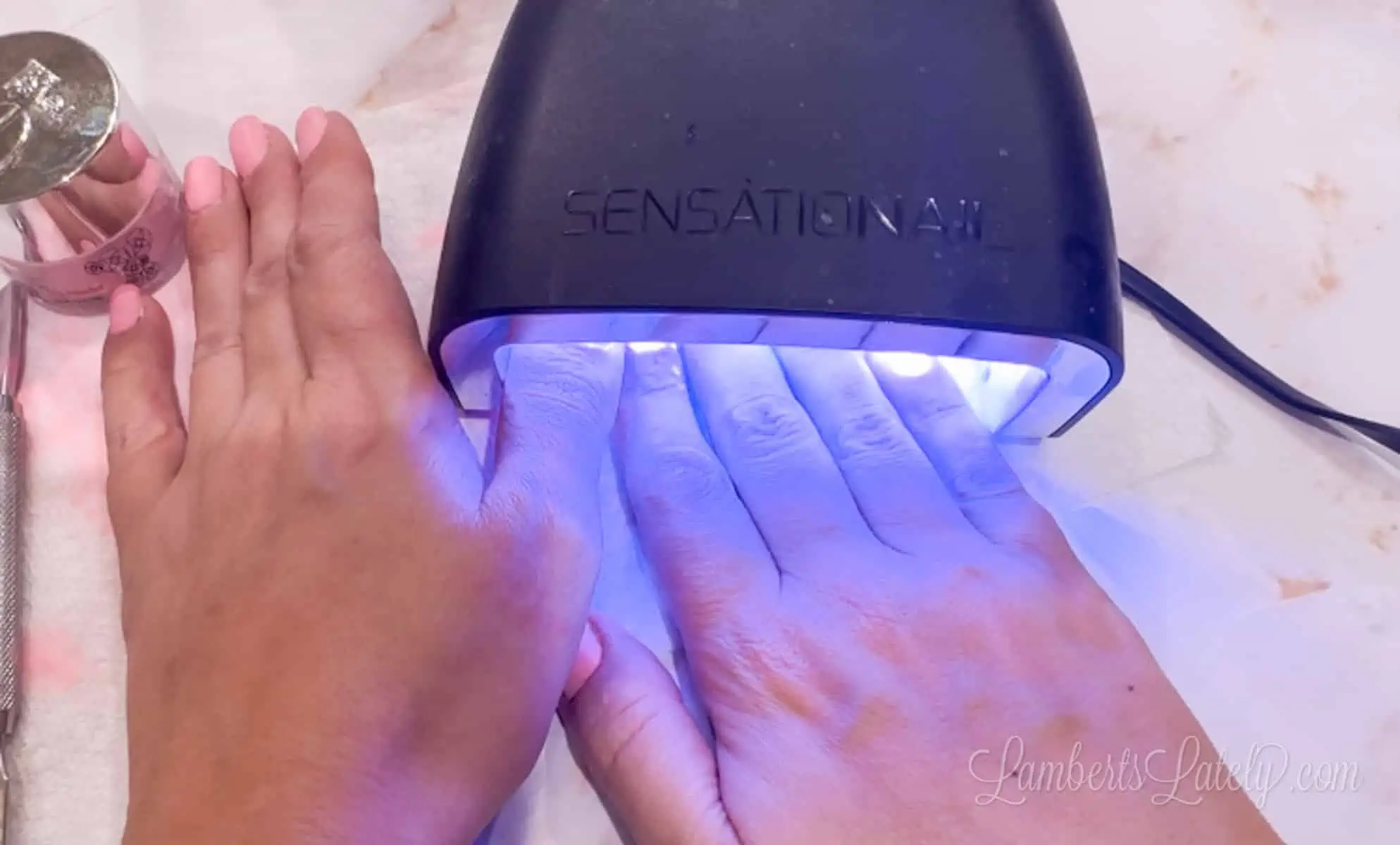 curing nails under uv lamp.