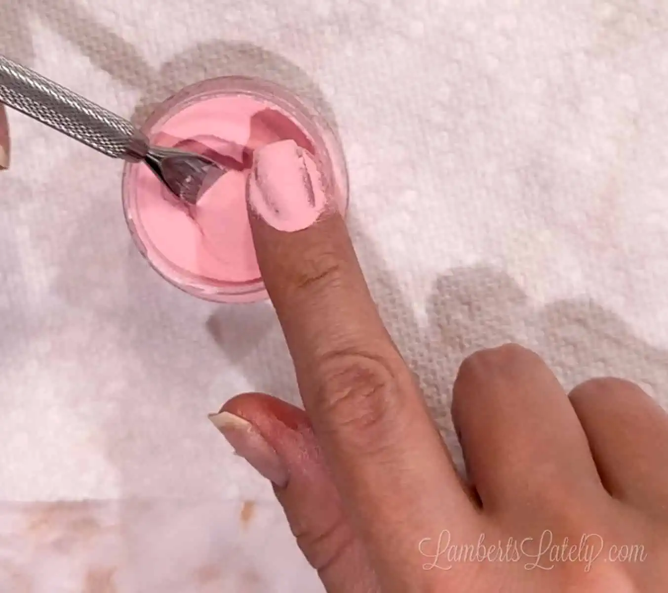pouring dip powder over nail.