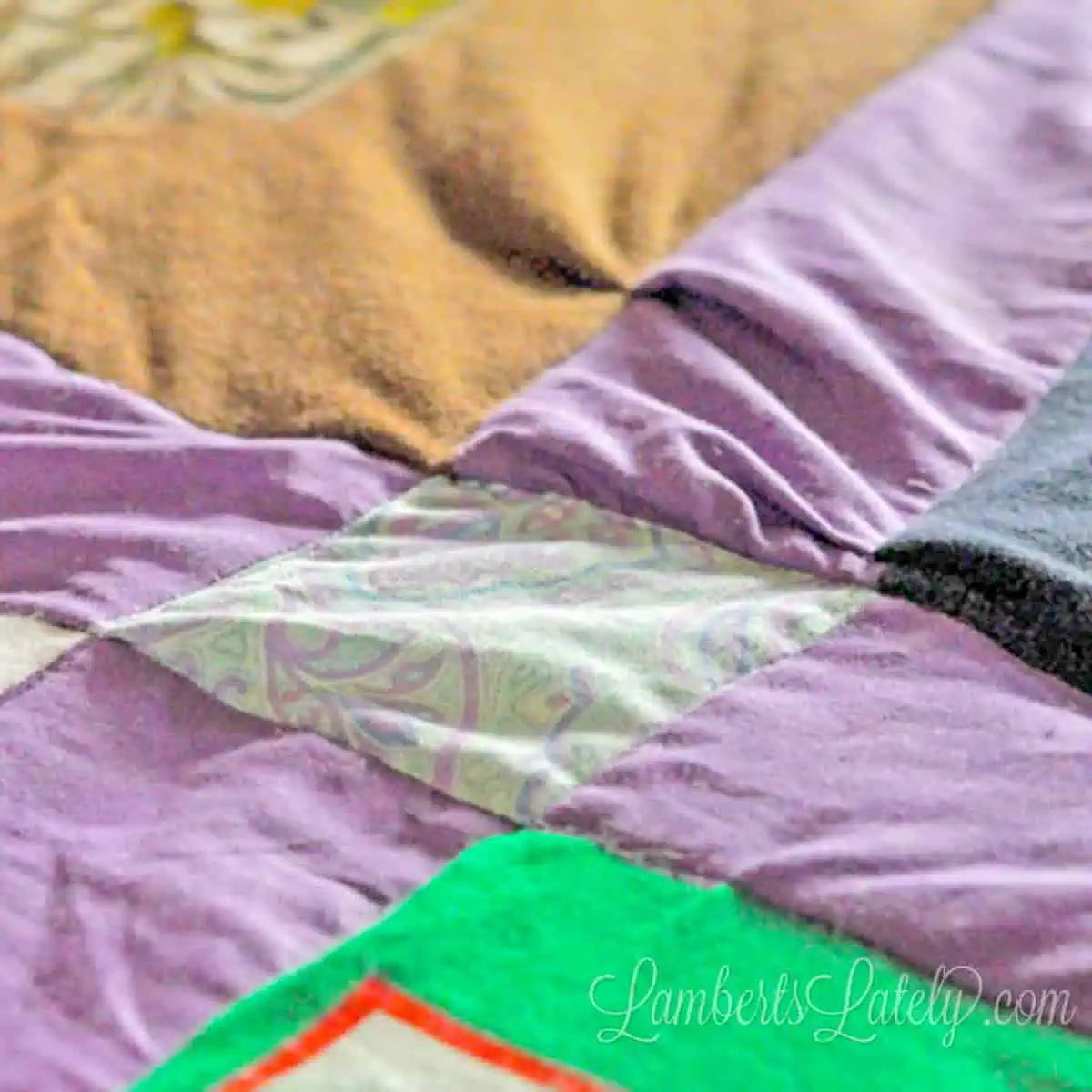 Close-up of T-shirt blocks and fabric sashing in a handmade quilt.