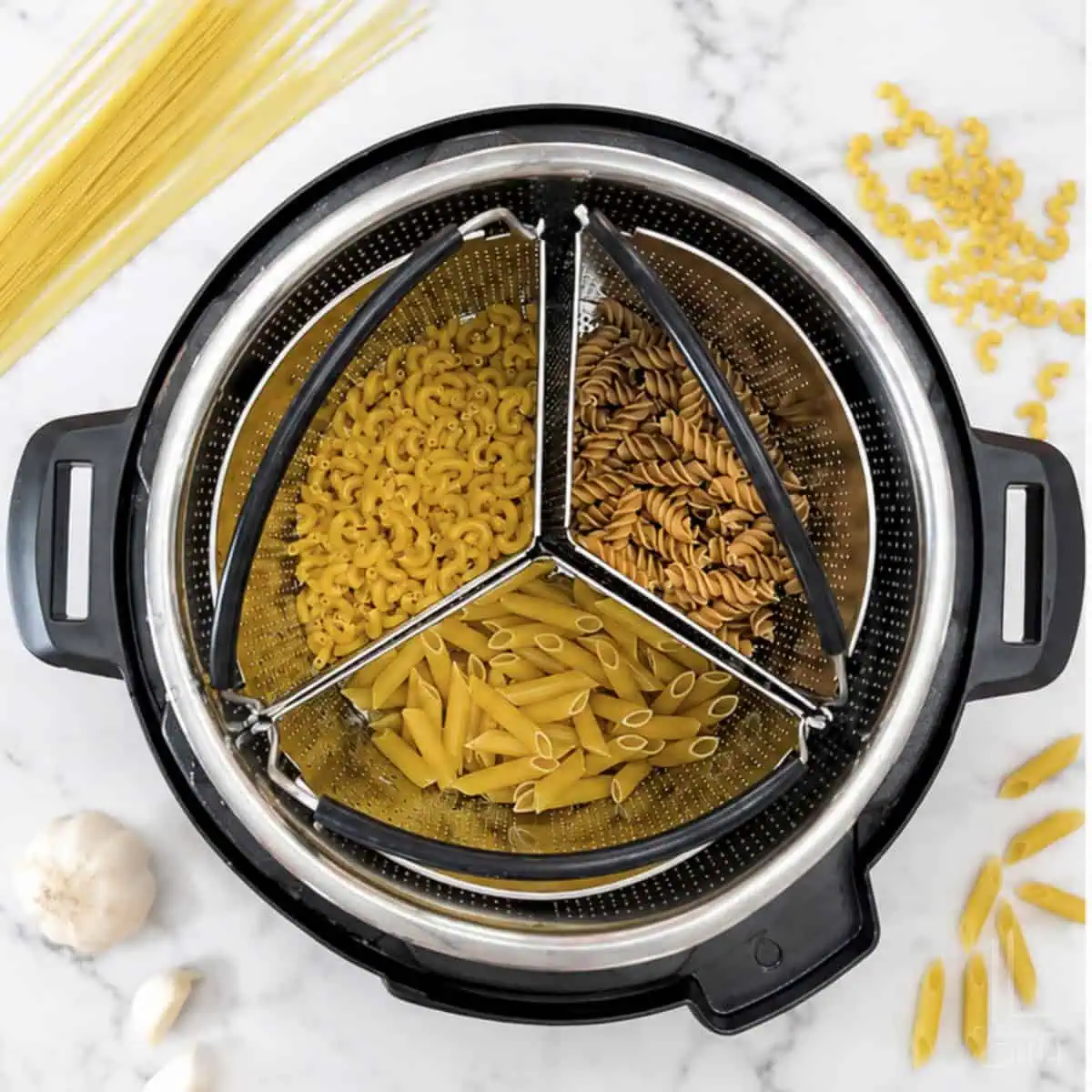 Trio of cooked pasta types in a steamer basket for Instant Pot cooking.